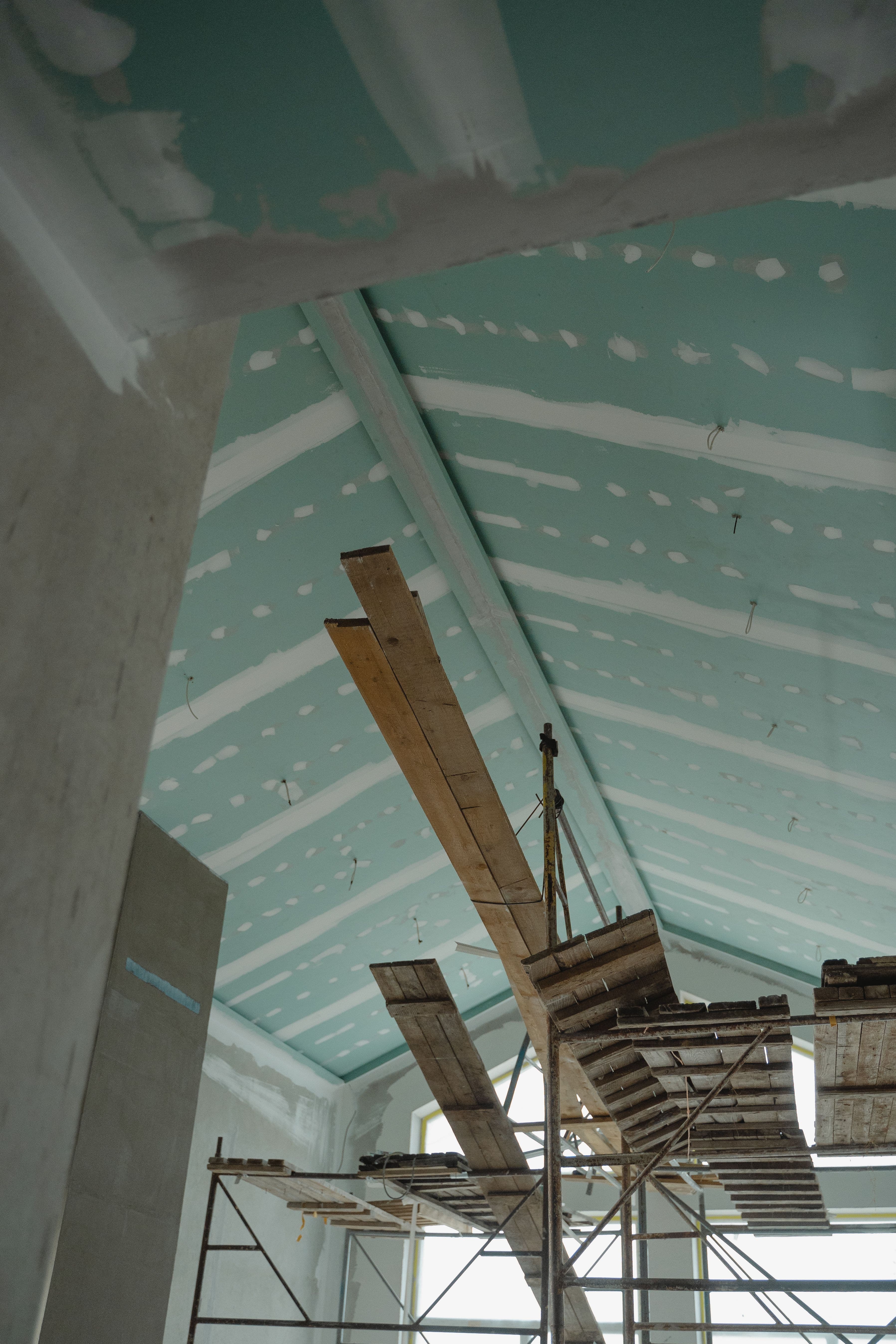 Vaulted drywall ceiling installation with elevated work platforms