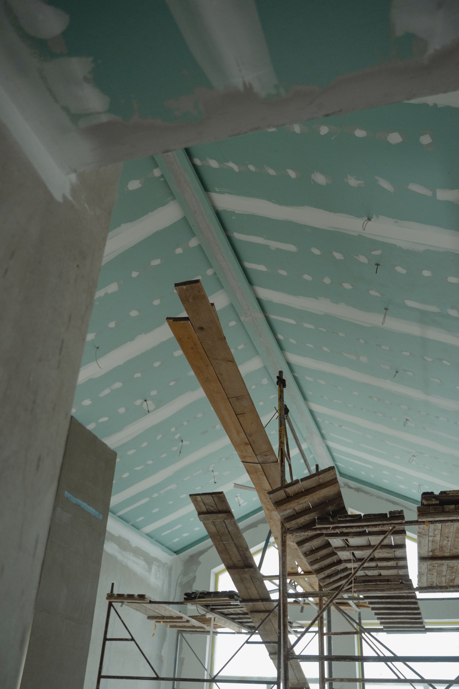 Vaulted drywall ceiling installation with elevated work platforms